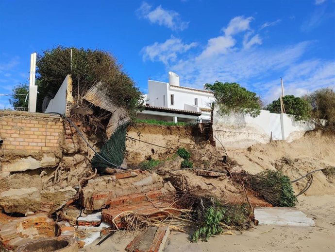 Imagen del estado de la playa de El Portil (Huelva) este fin de semana tras el temporal y de la caída de un muro cercano a una vivienda.