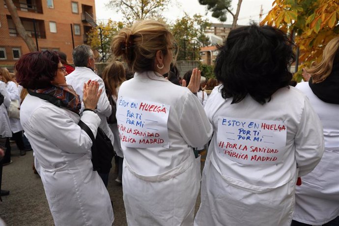 Tres sanitarias con carteles en sus batas blancas participan en una concentración organizada por el sindicato Amyts