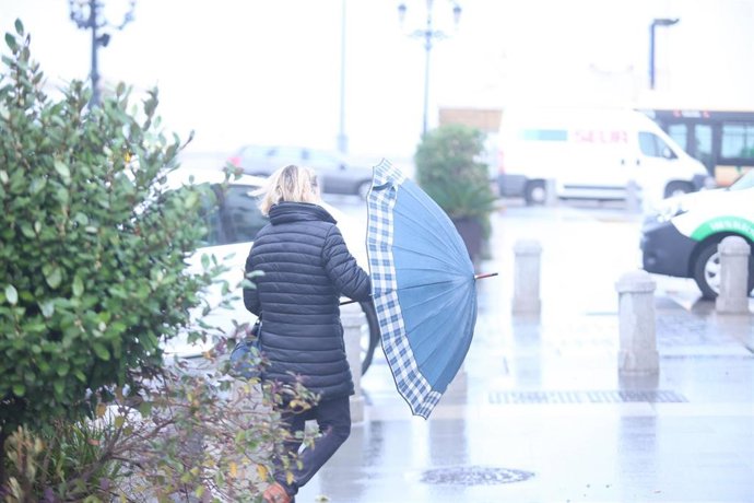 Una persona abre su paraguas para resguardarse de la lluvia en Cádiz