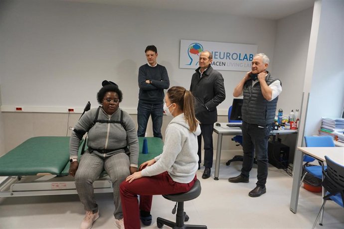 Amaia Aguas Ayesa, terapeuta de Adacen, y Julia Ngui Bisobe, usuaria de Adacen, probando un exoesqueleto de uso industrial para la rehabilitación de personas afectadas de hemiparesia.