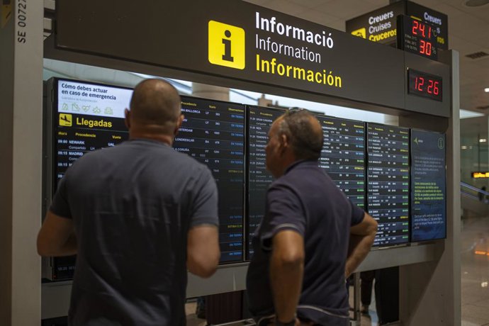 Archivo - Varias personas observan un panel de llegadas en el aeropuerto de Barcelona, a 4 de noviembre de 2022, en Barcelona, Catalunya (España). El cierre del espacio aéreo en Catalunya desde hoy por la mañana ha afectado a 159 vuelos entre los aeropu