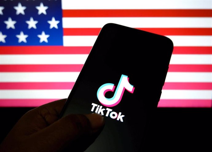 Archivo - Logotipo de TikTok sobre un fondo con la bandera de Estados Unidos.