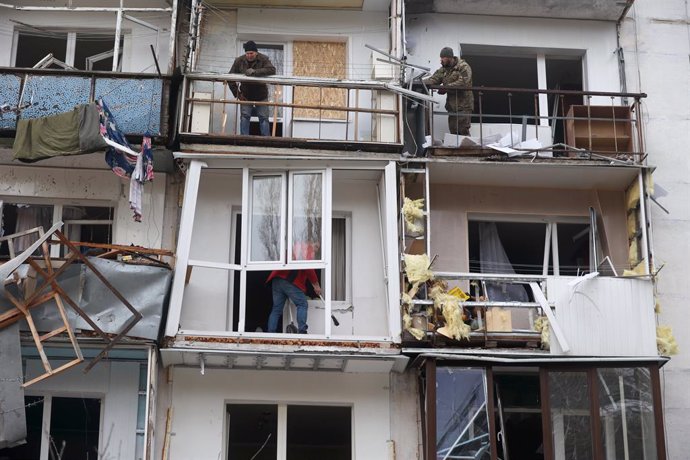 02 December 2022, Ukraine, Kharkiv: Men stand on the damaged balconies of an apartment building ruined by a Russian rocket strike. Photo: -/Ukrinform/dpa