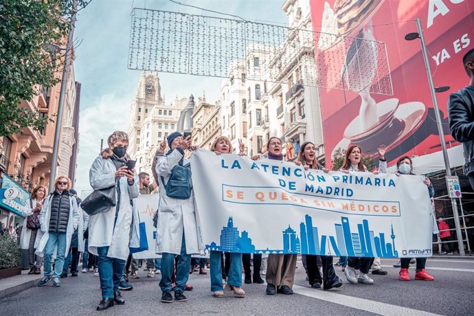 Varias personas caminan con una pancarta que reza 'La atención primaria de Madrid se queda sin médicos' durante una manifestación de médicos y pediatras