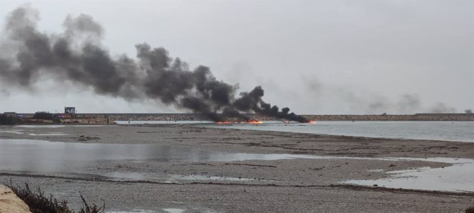 Barco incendiado en la bocana del puerto deportivo de Almerimar en El Ejido (Almería).