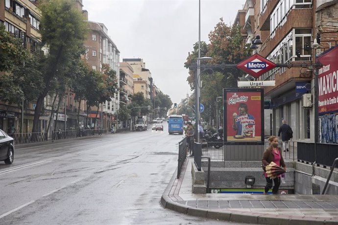 Archivo - Una mujer con paraguas sale de la parada del metro de Urgel