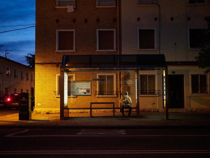 Archivo - Una persona espera en una marquesina la llegada de la villavesa (archivo)