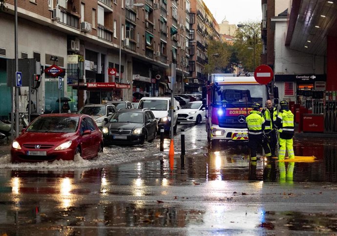 Una fila de coches circulan por una balsa de agua, en la Avenida de la Ciudad de Barcelona.