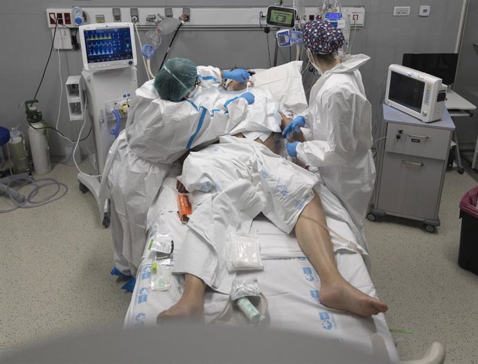 Archivo - Varios sanitarios alrededor de un paciente ingresado en una UCI.