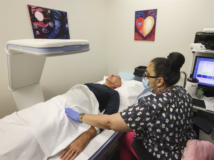 Archivo - Una técnica de radiología examina a un paciente mientras le realiza un escáner de médula ósea para detectar osteoporosis y osteopenia. En Moffitt Cancer Center, en Tampa (Florida, Estados Unidos), a 27 de octubre de 2022.