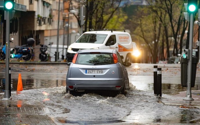 Un coche circula por una balsa de agua, en la Avenida de la Ciudad de Barcelona, a 14 de diciembre de 2022, en Madrid (España). 