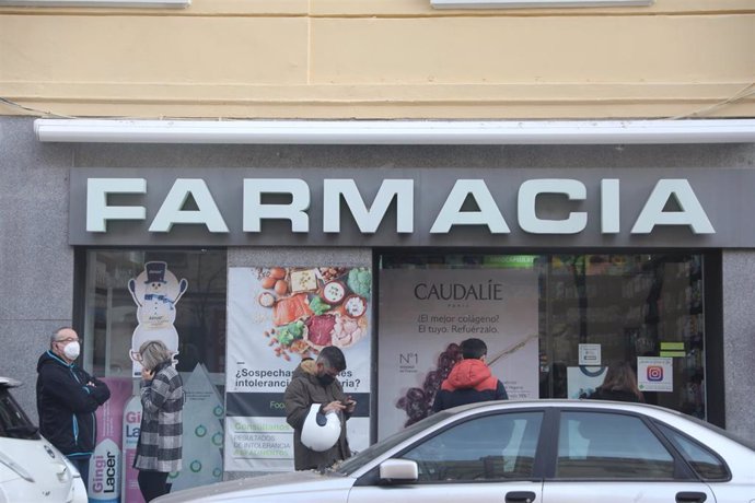 Archivo - Varias personas hacen cola en una farmacia para adquirir un test de antígenos, a 23 de diciembre de 2021, en Madrid, (España). 