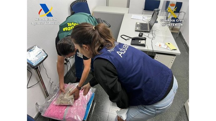 Agente de Guardia Civil y de Aduanas pesando la droga incautada