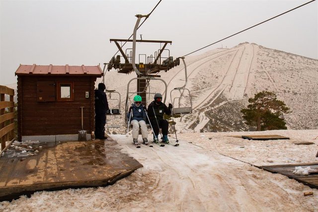 Archivo - Dos personas en la telesilla de la Estación de Esquí de Navacerrada.