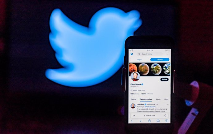 December 7, 2022, India: In the photo illustration, Elon Musk's twitter account is seen displayed on a mobile phone screen with the twitter logo on the background.