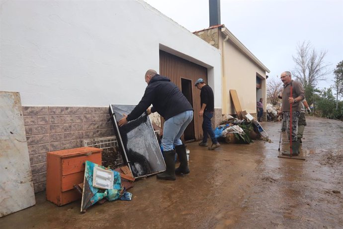 Los vecinos transportan materiales tras el paso de la borrasca Efraín, en Roca de la Sierra, Cáceres.