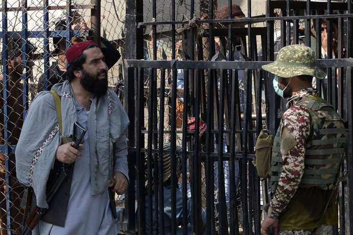 Un talibán y un militar paquistaní conversan en un paso fronterizo