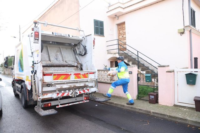 Un trabajador realiza el servicio 'puerta a puerta' de recogida de residuos en Palma.