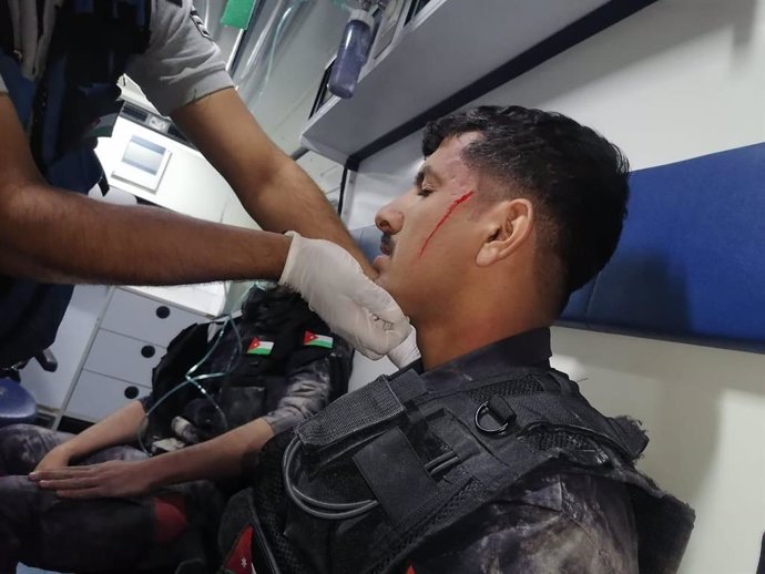 Archivo - 06 June 2021, Jordan, Amman: Security personnel receives medical attention inside an ambulance vehicle after they got injured during riots. The Jordanian interior ministry said that on Saturday evening there were armed attacks on security forc