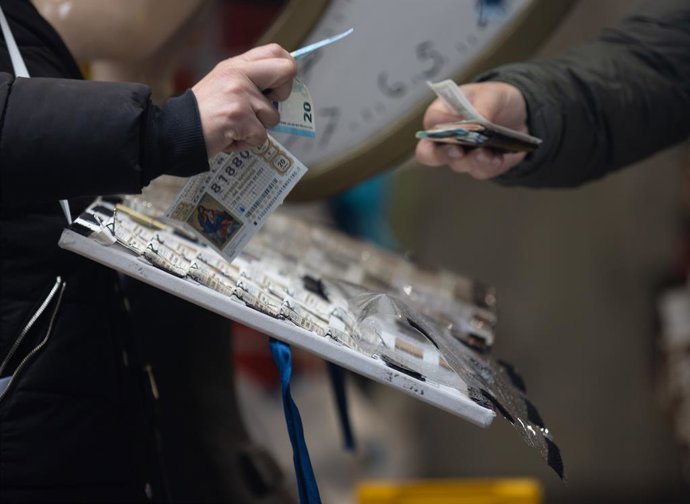 Una persona compra Lotería de Navidad, a 9 de diciembre de 2022, en Madrid (España). El Sorteo Extraordinario de Navidad 2022 se celebrará el próximo 22 de diciembre, y repartirá 2.520 millones de euros. Este año se ha incrementado el número de series e