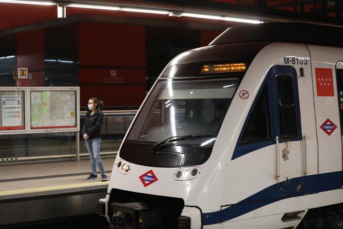 Archivo - Una mujer espera la llegada de un tren de Metro de Madrid en uno de los andenes 