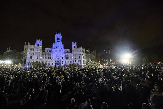 Numerosas personas observan y registran con sus móviles el espectáculo visual realizado mediante videomapping en la fachada del Ayuntamiento de Madrid