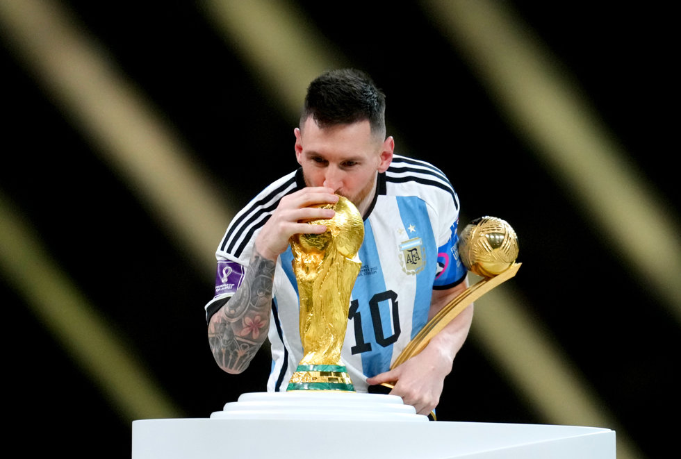 18 December 2022, Qatar, Lusail: Argentina's Lionel Messi kisses the World Cup trophy during the awards ceremony after the FIFA World Cup Qatar 2022 final soccer match between Argentina and France at the Lusail Stadium. Photo: Nick Potts/PA Wire/dpa