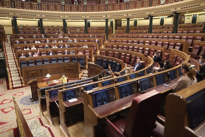 Archivo - Asistentes votan en una sesión plenaria en el Congreso de los Diputados, en una imagen de archivo.