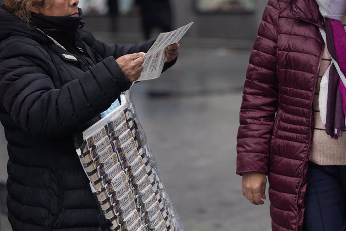 Una persona vende Lotería de Navidad, a 9 de diciembre de 2022, en Madrid (España). El Sorteo Extraordinario de Navidad 2022 se celebrará el próximo 22 de diciembre, y repartirá 2.520 millones de euros. Este año se ha incrementado el número de series em