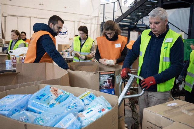 Un grupo de voluntarios almacena alimentos en cajas en la Fundación Banco de Alimentos 