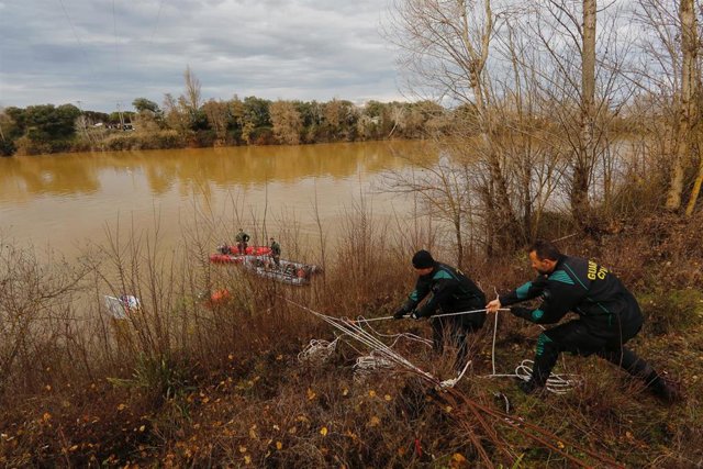 Efectivos de los GEAS trabajan para reflotar los restos del ultraligero que se accidentó este sábado en las aguas del Duero a su paso por Villamarciel y de cuyo interior se ha recuperado ya uno de los cadáveres de las dos personas que viajaban en él.