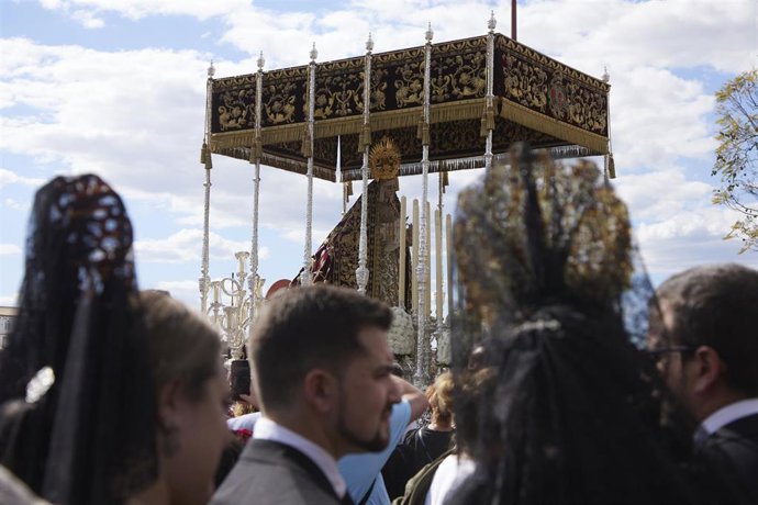 Archivo - Dos mujeres vestidas de Mantilla ven el paso de la Virgen de la Victoria, en la Semana Santa en Sevilla 2022. Jueves Santo a 14 de marzo de 2022 