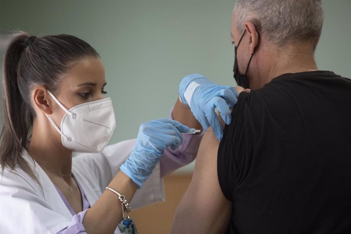 Archivo - Una enfermera vacuna a un hombre contra la gripe y el Covid, foto de recurso
