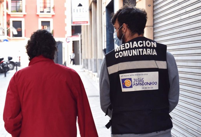 Un miembro de Jesús Abandonado atiende a un usuario de la Fundación