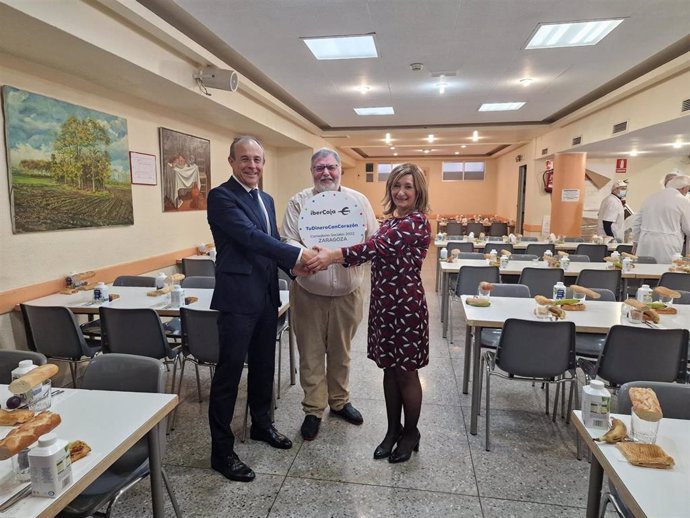 El director de la Dirección Territorial de Aragón de Ibercaja, Antonio Lacoma, entrega el importe de la donación al delegado parroquial para la Obra Social de la Parroquia del Carmen de Zaragoza, el Padre Ramón Maneu.