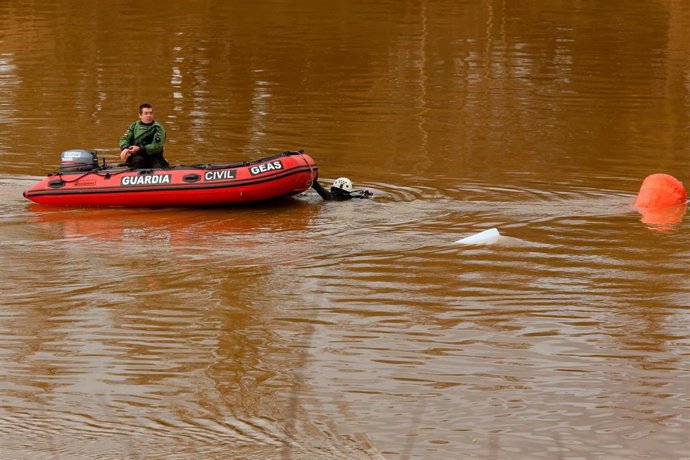 Un Efectivo del Grupo Especial de Actividades Subacuáticas (GEAS) de la Guardia Civil en una lancha en la pesquera de Villamarciel. 