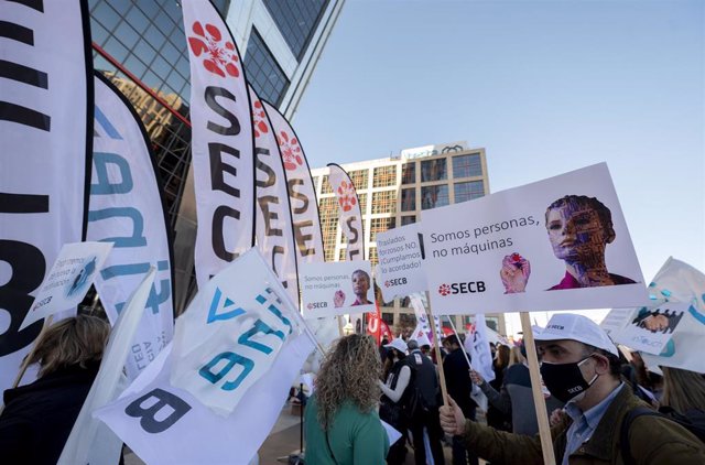 Archivo - Un grupo de personas pertenecientes a los sindicatos CCOO, UGT y SECB llaman a las plantillas de CaixaBank a movilizarse frente a las Torres Kio, a 22 de febrero de 2022, en Madrid (España).