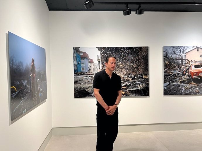 Cary Fukunaga posa junto a sus imágenes durante la presentación de su exposición 'Lyuta Vesna- Lost Spring' en Leica Gallery Madrid.