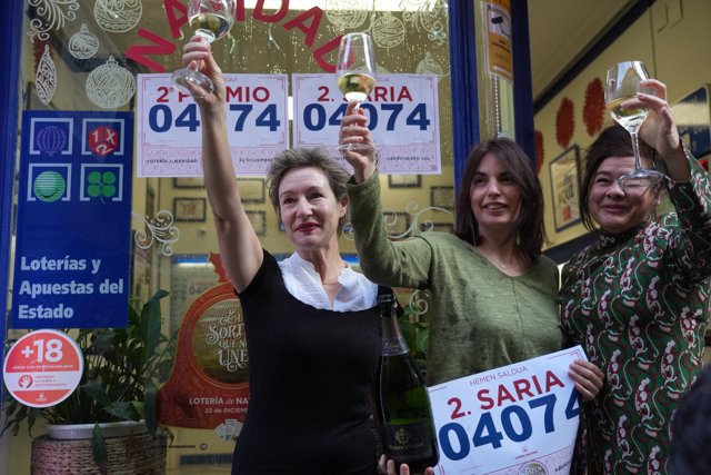 Una empleada de la administración situada en la calle Ledesma celebran que han vendido parte del número 04074 correspondiente al  'Segundo Premio’' del Sorteo 