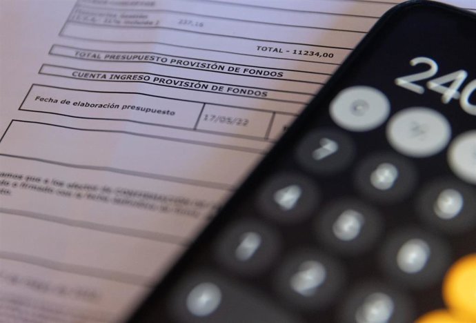 Archivo - Una calculadora y una escritura de compraventa de una hipoteca, en una imagen de archivo.