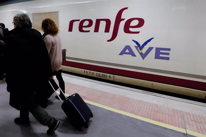 Dos pasajeros pasan por delante del primer tren comercial de alta velocidad desde Murcia a Madrid