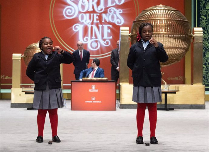 Ainhoa Rosero (i) y Yesica Paola Valencia (d) cantan un quinto premio del Sorteo Extraordinario de la Lotería de Navidad 2022, el número '43696', en el Teatro Real de Madrid, a 22 de diciembre de 2022, en Madrid, (España).