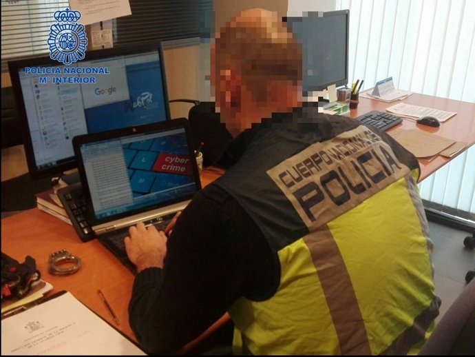 Archivo - Un agente de la Policía Nacional frente a un ordenador