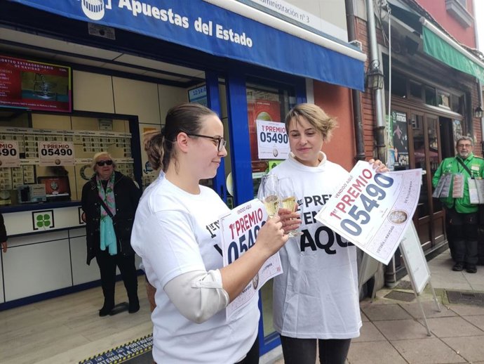 Las loteras Laura e Irene García Núñez, brindan tras repartir 41 series del 'Gordo' de la Lotería de Navidad en su Administración de Loterías, ubicada en la localidad asturiana de Moreda de Aller.