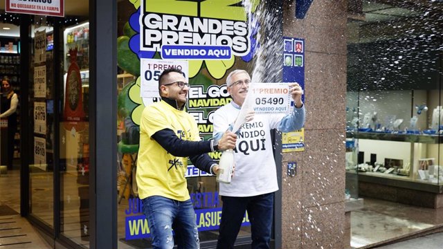 Dos empleados de la administración situada en la calle Ramón González celebran que han vendido parte del número 5490 correspondiente al 'Gordo' en O Porriño, Pontevedra, Galicia (España).