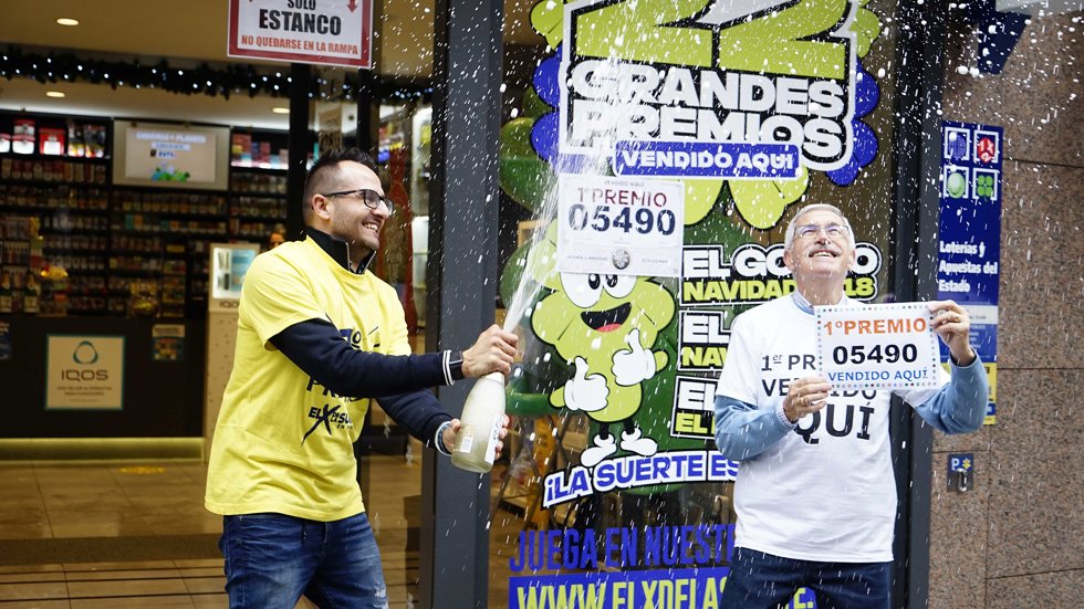 Dos empleados de la administración situada en la calle Ramón González celebran que han vendido parte del número 5490 correspondiente al 'Gordo' en O Porriño, Pontevedra, Galicia (España).