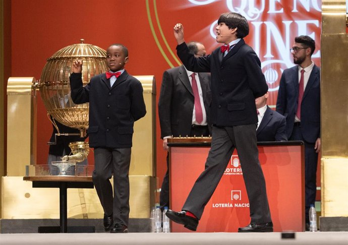 Ángel Abaga (i) y Alonso Dávalos (d) de la residencia de San Ildefonso cantan el Premio 'Gordo' del Sorteo Extraordinario de la Lotería de Navidad 2022, el número '05490'