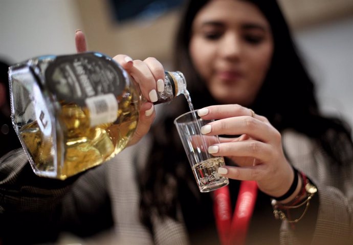 Archivo - Una mujer sirve tequila en un vaso