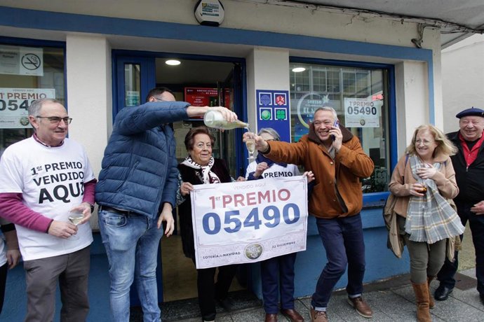 Empleados de la administración situada en la Avenida de Galicia celebran que han vendido parte del número 5490 correspondiente al 'Gordo' del Sorteo Extraordinario de la Lotería de Navidad junto  a agraciados del número.