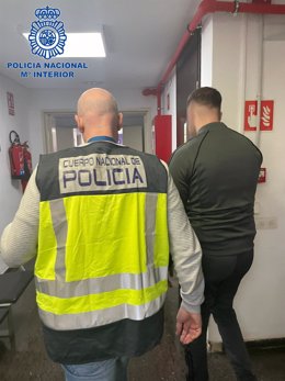 Un agente de la Policía Nacional en Palma junto a uno de los asaltantes detenidos.
